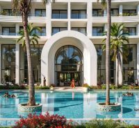 A pool at a luxury hotel with palm trees in Paje.