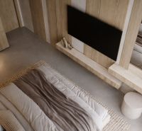A bedroom in a two-room apartment with neutral tones and natural materials.