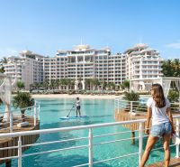 A luxury beachfront building in Paje, surrounded by palm trees and crystal-clear water.