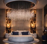 Luxurious bedroom with a dominant circular bed, a striking chandelier, and wooden decorations.