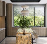 A kitchen in a large apartment with a window view, a central table, and lighting fixtures.