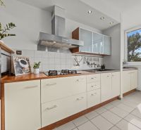 A kitchen in a 4-room apartment with white cabinets and built-in appliances.