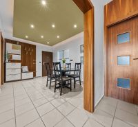 Dining room in a 4-room apartment with wooden doors and tiles, table with chairs.