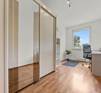 Home office with a desk, wardrobe, and wooden decor flooring.