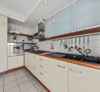 A kitchen in a 4-room apartment with kitchen cabinets, a sink, and built-in appliances.