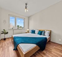 A bedroom with a wood-patterned floor and a bed in a 4-room apartment.