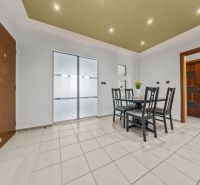 Dining table with chairs in a 4-room apartment with tiles and ceiling lights.