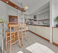 A kitchen in a 4-room apartment with a bar counter and light tiles.
