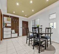 Dining area with a table and chairs in a 4-room apartment, tiled floor.