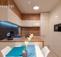 A kitchen in a model 2-room apartment with white cabinets and a wood-patterned floor.