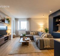 Living room in a two-room apartment with a wooden decor floor and a comfortable sofa.
