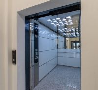 Interior of an elevator with stainless steel panels and a mirror, visible buttons.