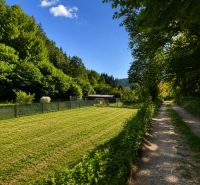 A plot for residential use in Kostiviarska, Banská Bystrica, next to Kostiviarska Road, surrounded by greenery.
