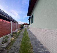 A family house on Kalvárska Street in Ružomberok with a paved walkway and a wooden fence.
