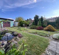 The garden of a family house on Kalvárska Road in Ružomberok with a pond and greenery.