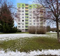 An apartment building surrounded by greenery and a snow-covered lawn on Novozámocká Street in Zvolen.