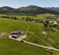 Residential plots in Lietavská Svinná-Babkov amidst green countryside with a village in the background.