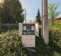 An open electrical cabinet among the greenery in Lietavská Svinná-Babkov for residential plots.