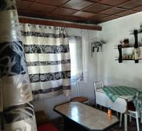 Living space in a cabin with a wooden ceiling and patterned curtains.