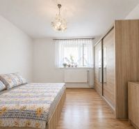 Bedroom in a family house with a wooden decor floor and a large wardrobe.