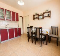 A kitchen and dining area in a family house with a red kitchen unit and table.