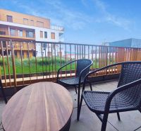 A balcony with rattan seating and a view of the architecture of Piaristická Street in Nitra.