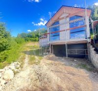 A family house under reconstruction with scaffolding, surrounded by nature in Badín, Banská Bystrica district, Slovakia.