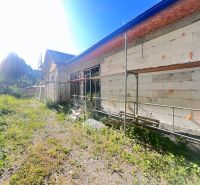 Construction of a family house in Badín, Banská Bystrica district, with green surroundings and scaffolding.