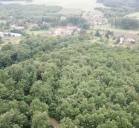 Aerial view of agricultural and forest lands near Trebušovce surrounded by greenery and rural areas.