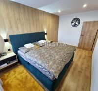 Elegant bedroom with wood-patterned flooring in a family house.