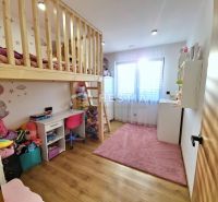 Children's room in a family house with a loft bed and a floor with a wooden decor.