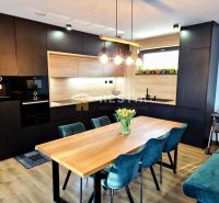 Modern kitchen in a family house with a wooden decor floor, blue chairs and a table.