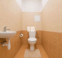 Bathroom in a 2-room apartment with a toilet, sink, and tiles.
