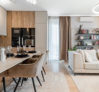 Open-plan three-room apartment with a kitchen, dining table, and comfortable living area.