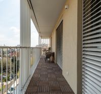 A balcony with a wooden decor floor in a 3-room apartment, view of Bratislava - Ružinov.
