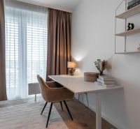 A workspace with a desk, a comfortable chair, and a shelf in a 3-room apartment.