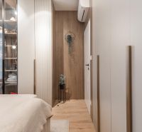 A cozy bedroom with a wood-patterned floor and a glass wardrobe in a 3-room apartment.