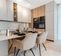 A stylish kitchen in a 3-room apartment with a dining table and a wooden decor floor.