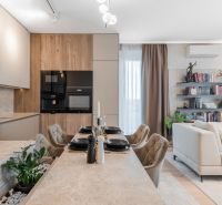 Kitchen and living room in a 3-room apartment with a wooden decor floor and a dining table.
