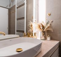 A bathroom with gold details and decoration in a 3-room apartment.