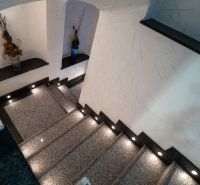 A staircase with stone steps and interesting wall texture in a building.