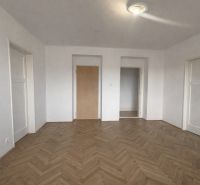 Interior of a 2-room apartment with white walls and a floor with a wooden decor.