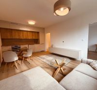 Living room with wood-patterned flooring and kitchen in a 3-room apartment.