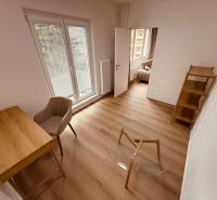 A room with a wooden floor decor in a 3-room apartment, a desk, a chair, a shelf.