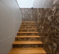 A staircase with a wood-patterned floor and marble walls in manufacturing premises.