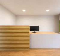 Reception in manufacturing premises with a counter and a cabinet, floor with wood decor.