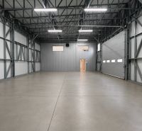 Production premises with a steel structure, concrete floor, and large entrance doors.