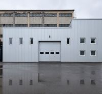 Production premises with a gray facade and garage doors in Zlatý Potok, Zvolen.