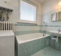 Bathroom in a 2-room apartment with a bathtub, sink, and washing machine.