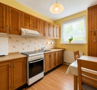 A kitchen in a two-room apartment with a kitchen unit and a wooden decor floor.